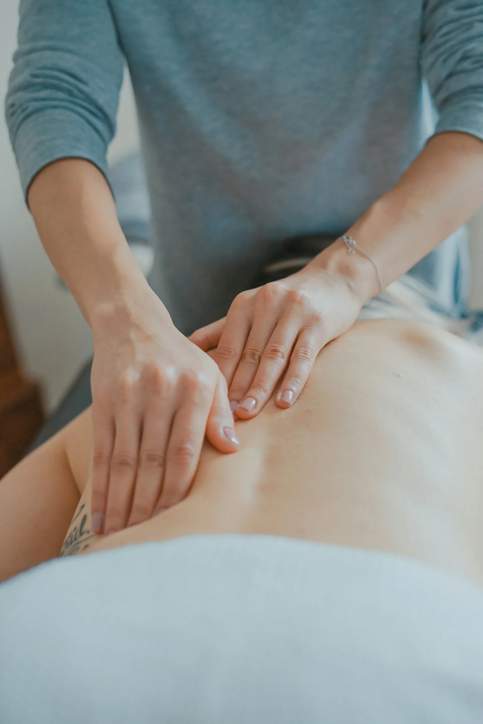 Couples massage setup with two massage tables side by side in a living room
