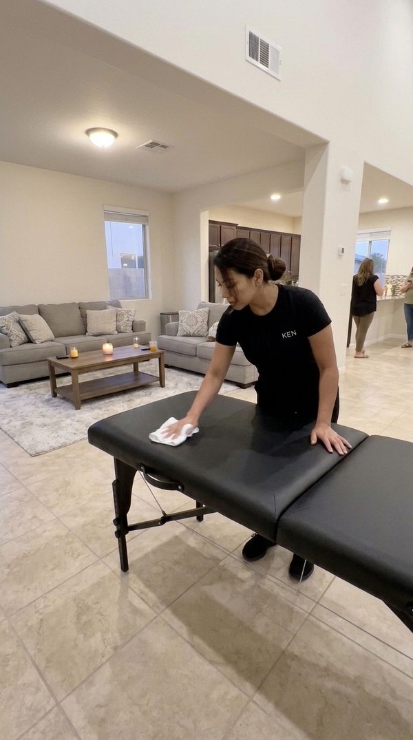 Therapist wiping the massage table clean between guests
